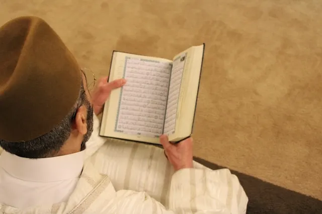 مرد در حال خواندن قرآن